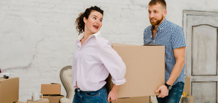 Dvoje mladih nose kutije za selidbu