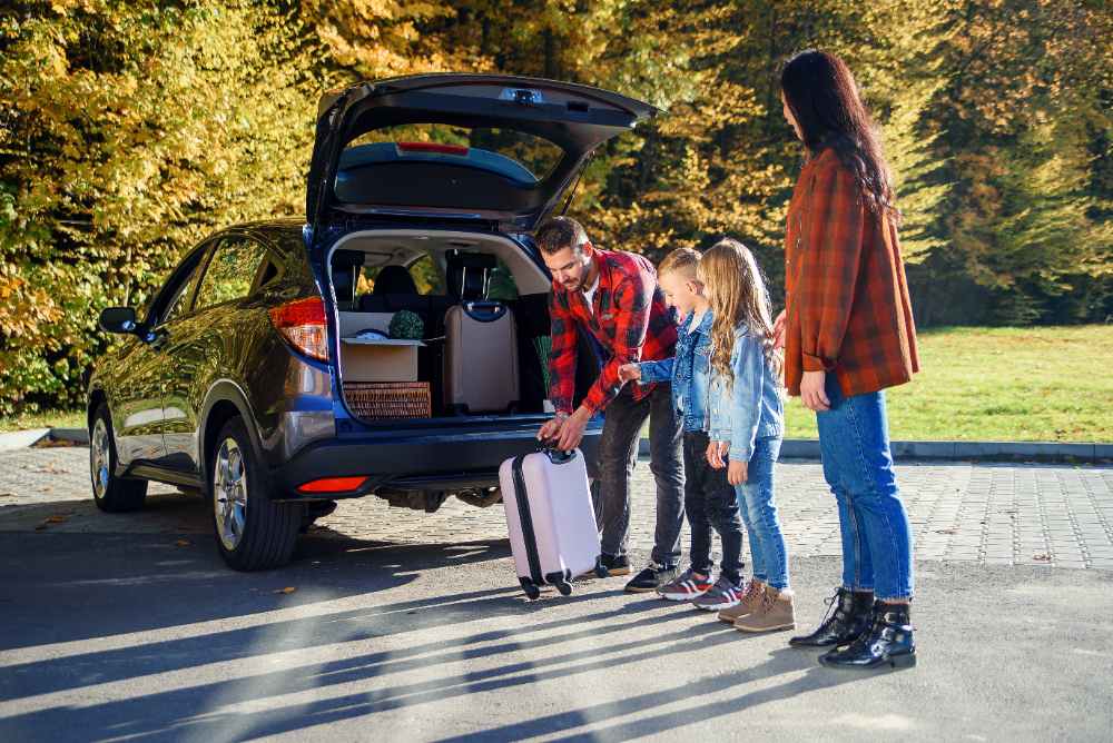 porodica pakuje kofere u automobil 