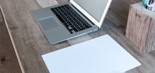 otvoren laptop i papir na stolu