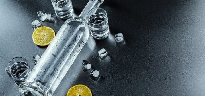 polozena flasa sa votkom i case i limun oko nje